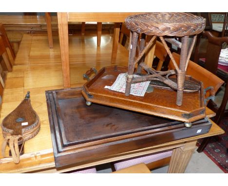A set of 3 graduating wooden trays; a 1930's oak tray with silver plated mounts; a cane work stool; a cribbage board; bellows