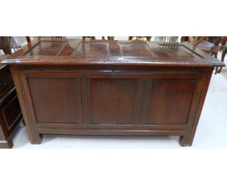 An early 18th century framed and panelled oak blanket box with hinged panelled lid and triple panel front, length 57"