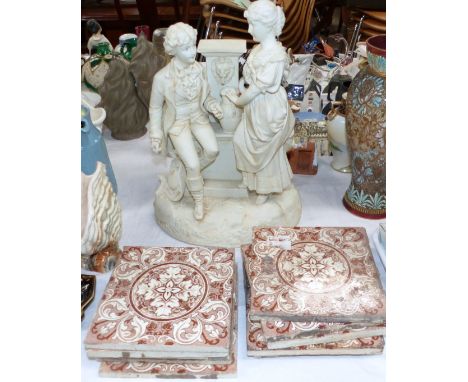 A Parian ware style group of male and female collecting water; a ceramic tile; a collection of vintage tiles