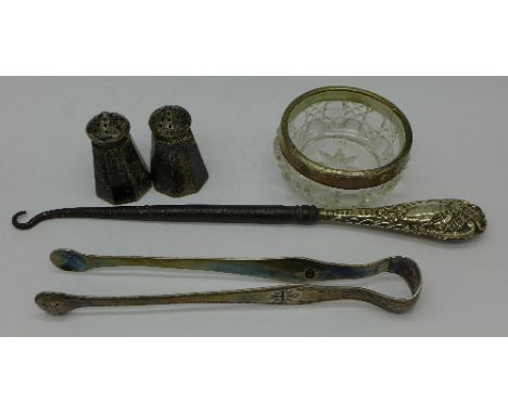 A pair of Georgian silver sugar bows, a/f, two sterling silver peppers, a silver rimmed salt and a button hook