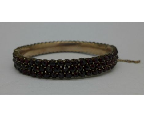 A Bohemian yellow metal and garnet bangle, 23.2g