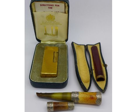 A Dunhill lighter, cased and three cheroot holders