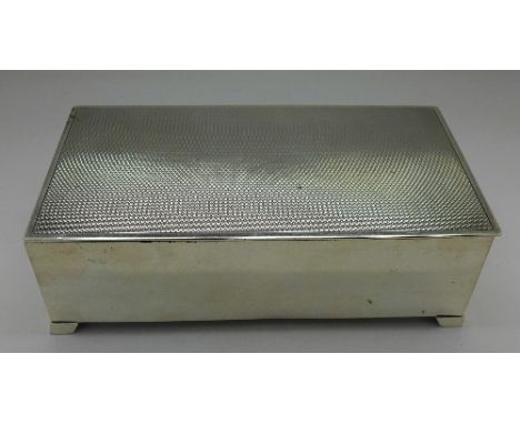 A silver cigarette box with engine turned decoration, London 1930, total weight 644g, width 18cm