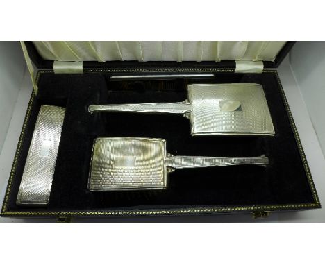 A silver mounted vanity set comprising two brushes, mirror and comb