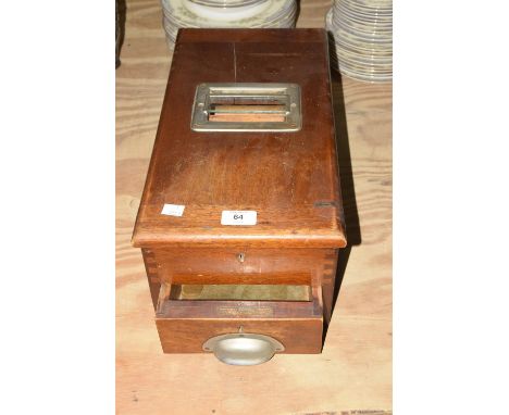A vintage mahogany cashiers till Of rectangular form with a front drawer applied with a metal cup handle, 44cm long. 