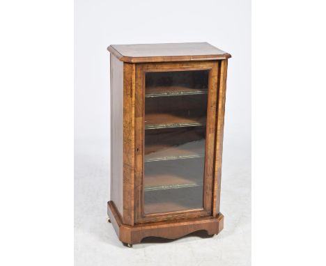 A Victorian burr walnut music cabinet The rectangular crossbanded and canted top above a single glazed door enclosing four sh