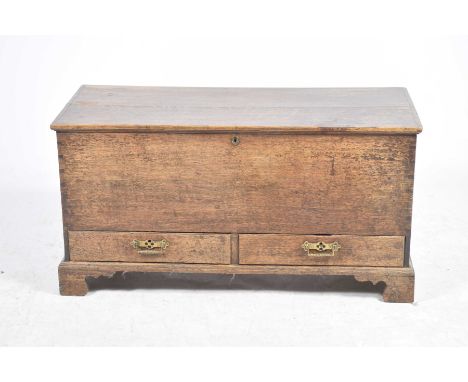 A 19th Century oak mule chestThe rectangular hinged top above a plain front and two lower frieze drawers each applied with br