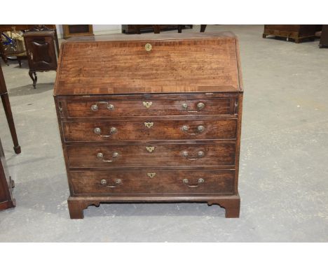 A George III mahogany bureauThe cross banded fall front enclosing a compartmentalised interior above four graduated cock bead