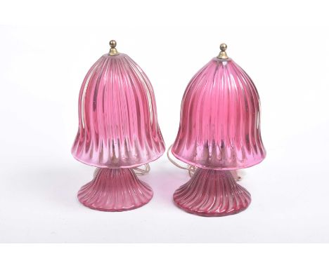 An unusual near pair of early 20th Century mushroom shaped cranberry glass table lamps Each lamp with a reeded helmet shaped 