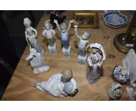 A collection of Lladro figuresTo include a girl cradling the earth, a Lladro Society ceramic scroll, a Lladro lady with an um