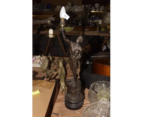 An early 20th Century Spelter figureModeled holding a torch aloft and an industrial cog raised upon a circular base embossed 