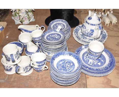 A large collection of blue and white table waresTo include Rayware, Willow Pattern cups, saucers and bowls along with Broadhu