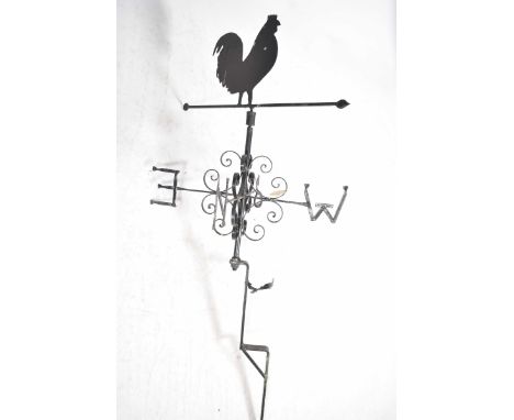 An iron weather vaneHaving a cockerel silhouette above a revolving pointer with scrolling brackets and the four directional p