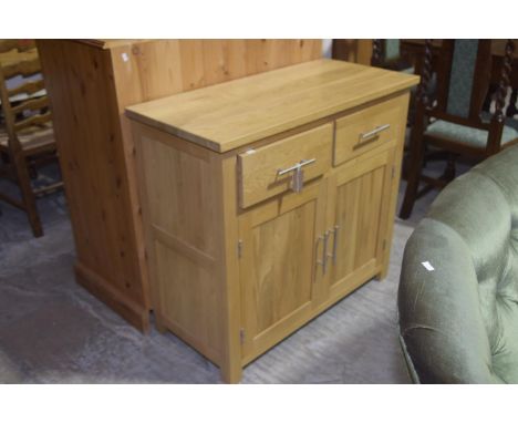 A contemporary light oak sideboardHaving a rectangular slab top above two frieze drawers and two cupboard doors each applied 