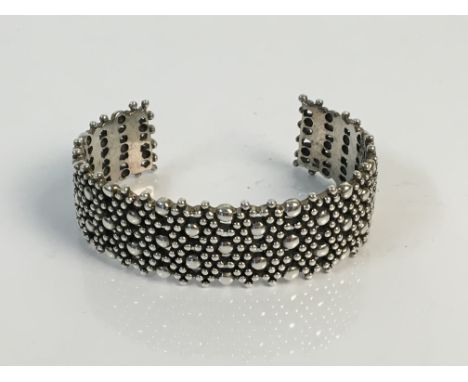 *A silver bangle 2cm in dotted and pierced design, weight 65gms. IMPORTANT: Online viewing and bidding only. No in person col