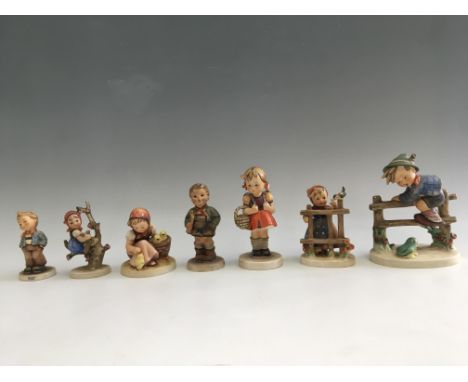 Seven Goebel figurines, including boy climbing fence, girl with bird, girl with chicks, girl on tree branch, etc. IMPORTANT: 