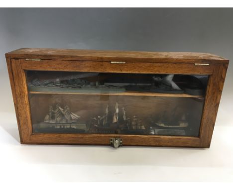 Twelve trench art model battleships in glass fronted case. IMPORTANT: Online viewing and bidding only. No in person collectio