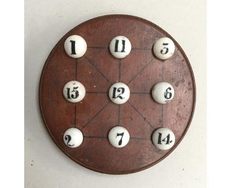 A set of nine vintage ceramic marbles, numbered to 15, on a circular wooden gaming board 