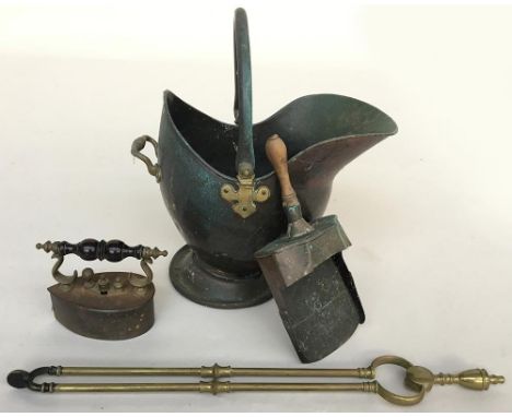 A copper helmet coal scuttle with brass fittings, together with a coal shovel and brass fire tongs, and an iron with turned w