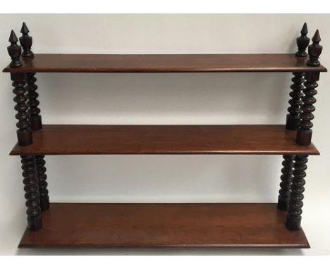 A mahogany hanging shelf, three shelves supported by ring turned columns with finials 