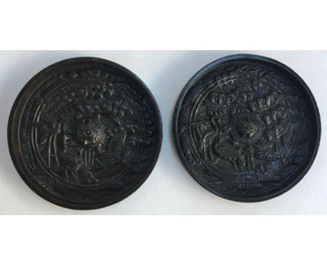 A pair of Japanese bronze mirrors, one side decorated with cranes among foliage around a central turtle, each 11cm diameter 