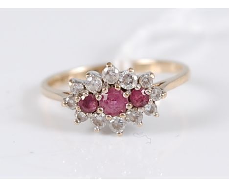 A 9ct ruby and white hardstone cluster ring, the three round rubies surrounded by small round white hardstones, all set in wh