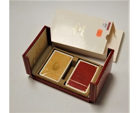 Two sealed packs of Le Must de Cartier playing cards in fitted red Moroccan leather case and card outer box