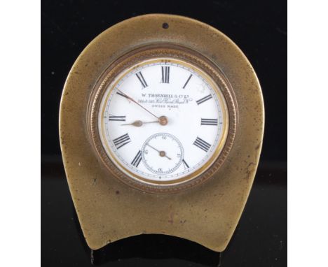 A late Victorian brass cased travel clock, the proud white enamel dial with Roman numerals and subsidiary seconds dial, signe