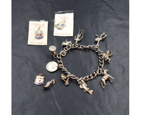 A silver charm bracelet, having nine white metal charms including a rabbit, a Norman soldier and a tankard, approximately 17.