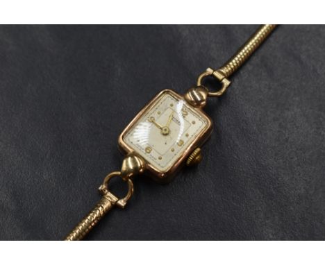 A 9ct gold Rotary wristwatch, the rectangular champagne dial having Arabic and dot numerals, on a 9ct gold bracelet strap, 12