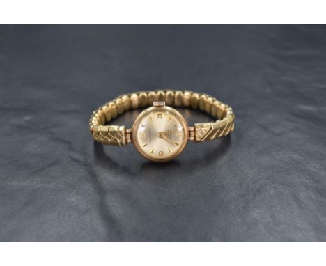 A 9ct gold Rotary wristwatch, the champagne dial having Arabic and baton numerals, on a 9ct gold plated bracelet strap, 15.9g