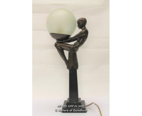 An Art Deco style table lamp with seated girl holding a glass ball, 48cm.