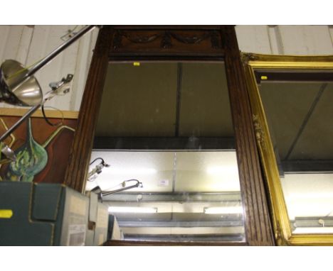 A large oak framed mirror with floral garland decoration 
