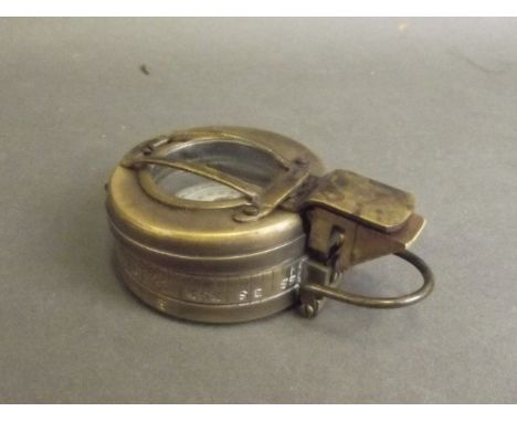 A brass cased field compass, inscribed 'T.G. Co. Ltd' to base, 2½'' diameter 