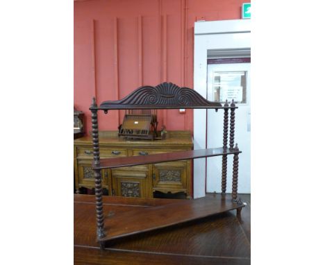 A George IV mahogany three tier wall hanging shelf 