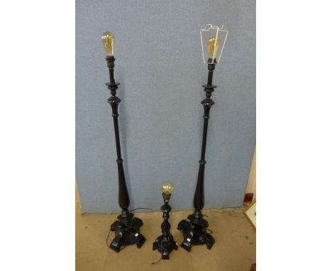 A pair of black standard lamps and matching table lamp 