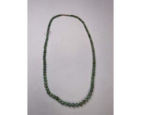 A strand of graduated jade beads with 9ct gold clasp. 62cm. 