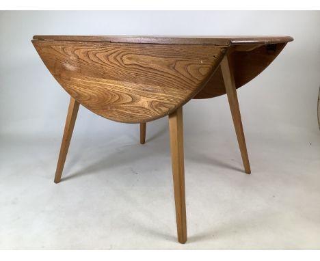 An Ercol blonde mid century elm drop flap dining table.W:63cm x D:113cm x H:72cmExtends to W:114cm x D:124cm x H:72cm