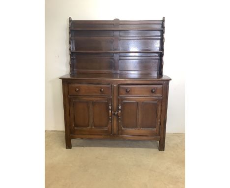 An Ercol mid century stained oak two piece dresser with plate rack top  sideboard beneath with two drawers and cupboard with 