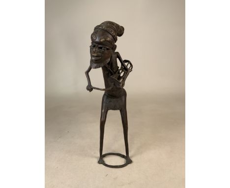 A West African Benin metal figure playing the drum. H:51cm.