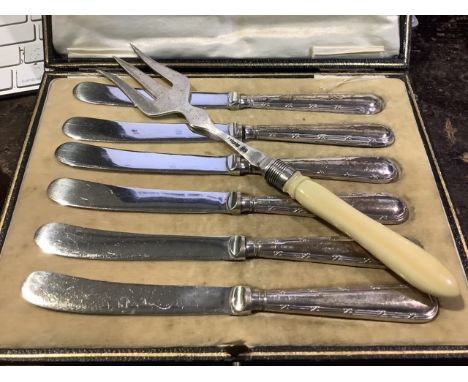 A boxed set of six sterling silver handled butter knives together with a sterling silver pickle fork. 