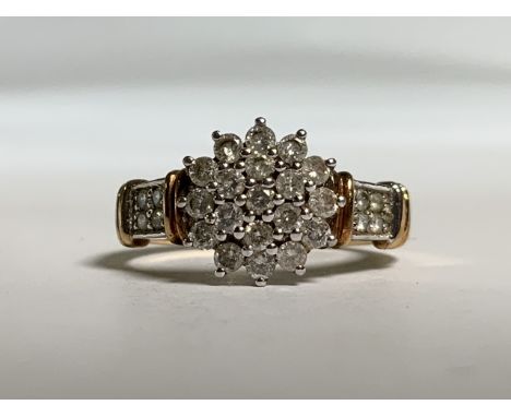 A 9ct gold diamond cluster ring. With diamond set shoulders. 2.7g. Size K. 