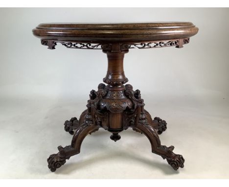 A Victorian walnut card table with heavily carved base on ceramic castors.W:86cm x D:47cm x H:72cm