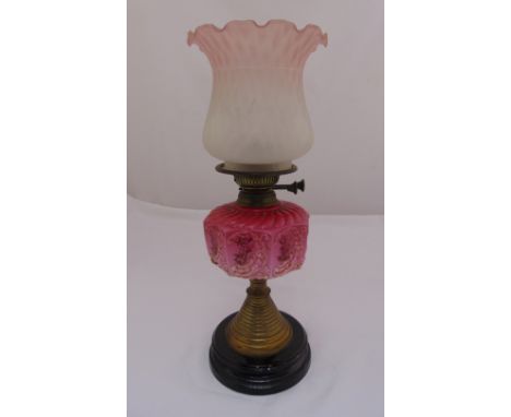 A Victorian brass oil lamp with octagonal ceramic reservoir, glass shade on turned wooden base, 49cm (h)
