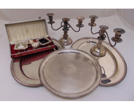 A quantity of silver plate to include trays, a pair of candelabra and cased condiments