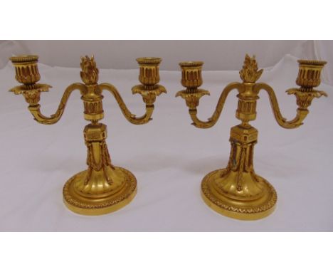 A pair of French 19th century ormolu two branch candelabra, the scrolling arms on raised columnular stems on raised circular 