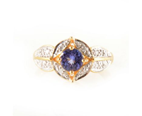 A tanzanite and diamond cluster ring, a circular faceted tanzanite surrounded by four brilliant cut diamonds with six brillia