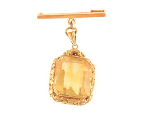 A yellow stone fob on a bar brooch, the rectangular step cut stone 18mm x 16mm, four claw set in an all yellow metal ornate m