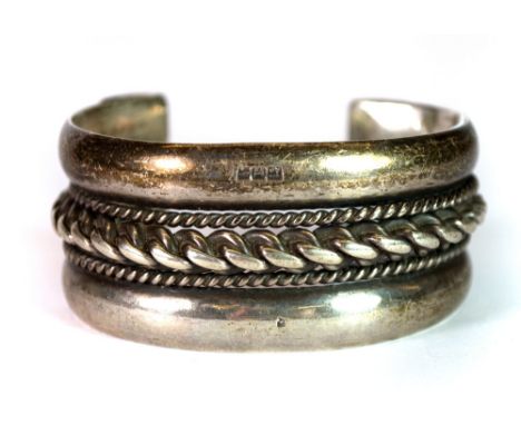 A heavy handmade Egyptian silver bangle, W. 2.8cm.