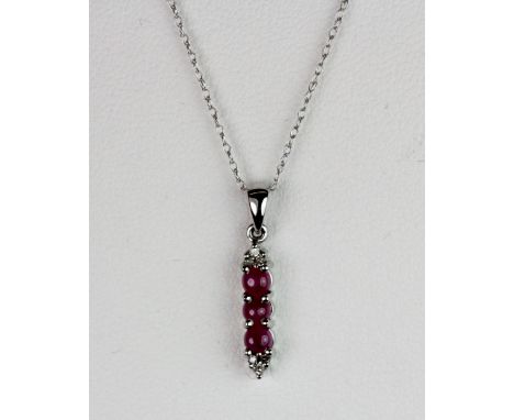 A 9ct white gold cabochon ruby and diamond pendant on a 9ct gold chain.